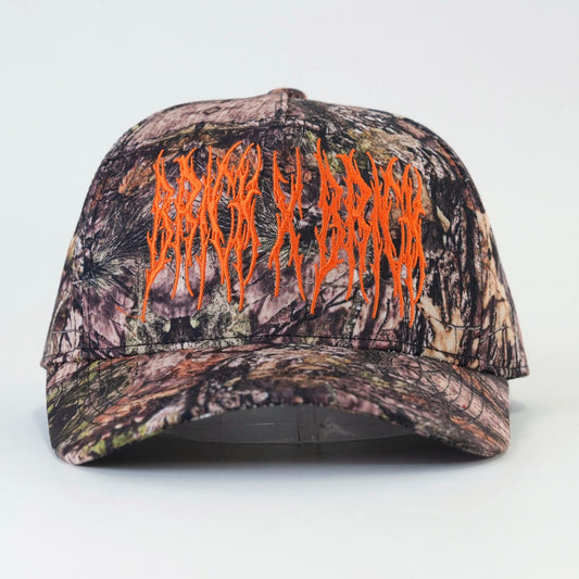 Camo Trucker Hat front view with orange Brick X Brick embroidery
