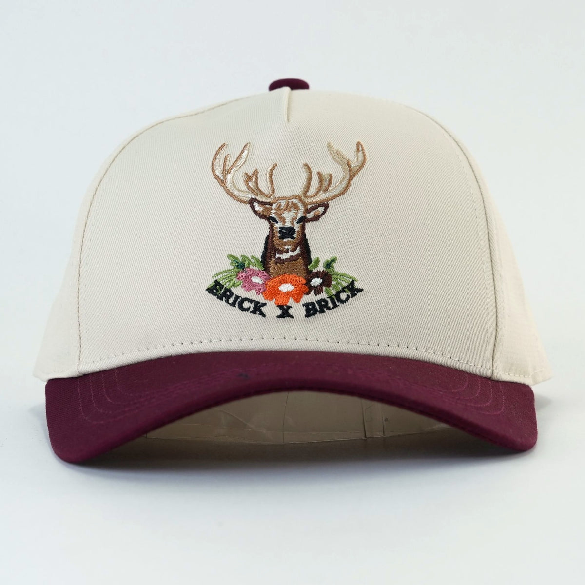 Cranberry Stag Cap, cream crown with maroon brim and embroidered stag